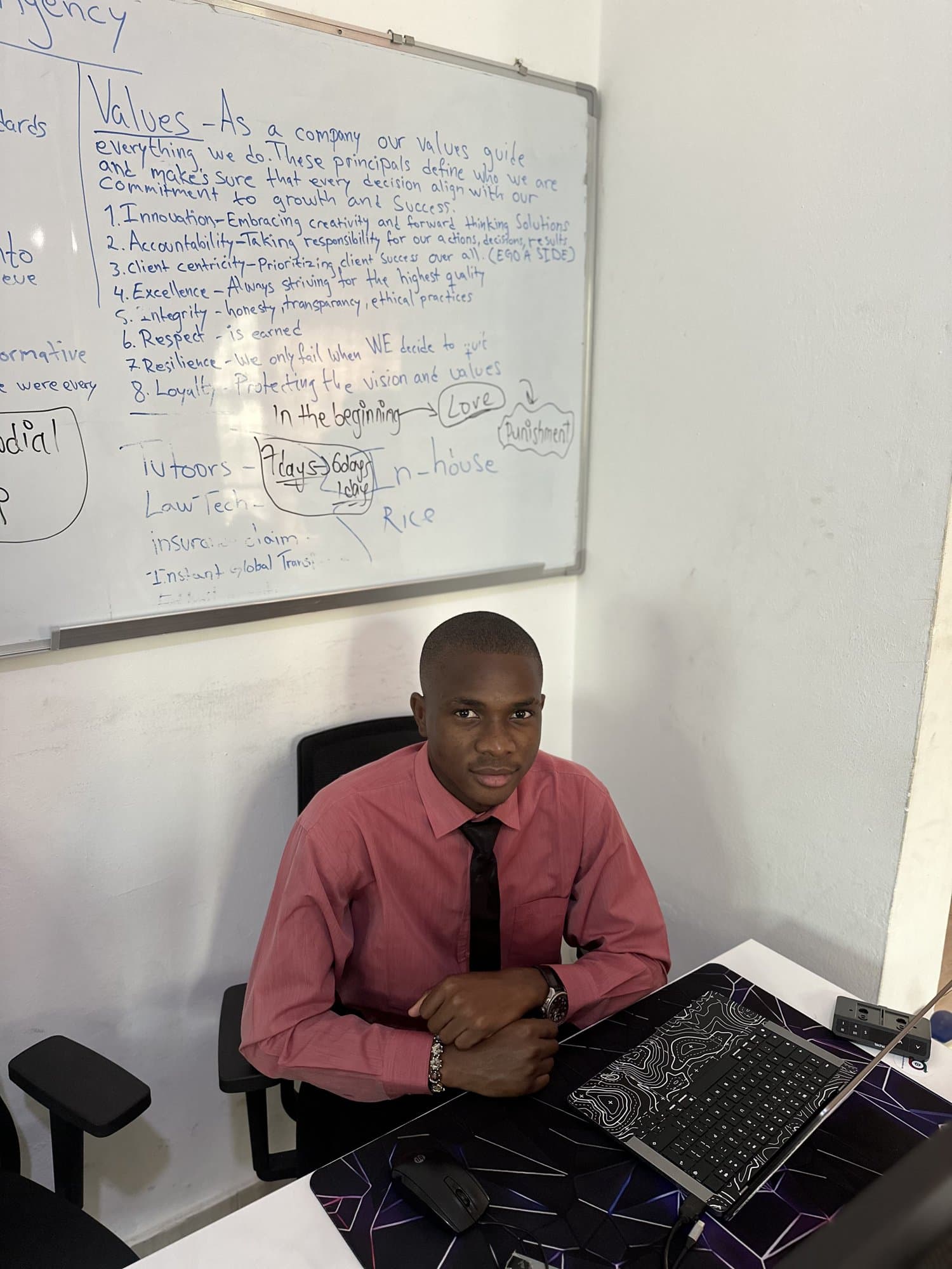 Jordan working on a laptop in front of a whiteboard